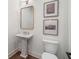 Chic powder room with a pedestal sink, framed mirror, and modern wall art at 5345 Keepsake Court, Cumming, GA 30040