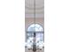 Elegant chandelier hangs beneath a tray ceiling, complementing the arched window at 23 Oxford Ln, Kingston, GA 30145