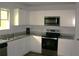 Modern kitchen featuring white cabinets, granite countertops, stainless steel appliances and luxury vinyl floors at 23 Oxford Ln, Kingston, GA 30145