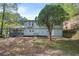 A view of the backyard and home's exterior, which features a tree and partial hillside at 2352 S Hairston Rd, Decatur, GA 30035