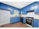 Bright kitchen features stylish blue cabinets, modern appliances and wood countertops at 2352 S Hairston Rd, Decatur, GA 30035