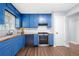 Bright kitchen features stylish blue cabinets, modern appliances and wood countertops at 2352 S Hairston Rd, Decatur, GA 30035