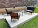 A concrete back patio with outdoor seating; two chairs, a table and a bench at 2512 Montezuma Cir, Ellenwood, GA 30294