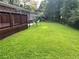 View of the expansive backyard with a deck and mature trees at 2512 Montezuma Cir, Ellenwood, GA 30294