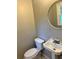 Small bathroom features a toilet, classic sink and round mirror at 2512 Montezuma Cir, Ellenwood, GA 30294