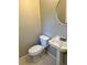 Small bathroom features a toilet, classic sink and round mirror at 2512 Montezuma Cir, Ellenwood, GA 30294