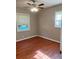 Bedroom featuring hardwood floors, neutral paint, a ceiling fan, and two windows at 2512 Montezuma Cir, Ellenwood, GA 30294