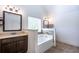 Bathroom featuring a soaking tub, tiled walls, and a dark wood vanity with mirror at 3228 Trinity Mill Cir, Dacula, GA 30019