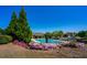 The community pool has lounge chairs, lush trees, and flowering bushes surrounding the fenced area at 3228 Trinity Mill Cir, Dacula, GA 30019