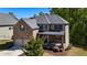 Beautiful two-story home featuring a brick facade, two-car garage, and covered front porch at 3228 Trinity Mill Cir, Dacula, GA 30019