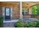 Inviting front porch featuring brick accents, a railing, and a well-manicured garden at 3228 Trinity Mill Cir, Dacula, GA 30019