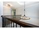 A hallway with dark wood railings and a modern, circular light fixture at 3228 Trinity Mill Cir, Dacula, GA 30019