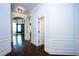 Bright hallway featuring dark hardwood floors and elegant white wainscoting throughout at 3228 Trinity Mill Cir, Dacula, GA 30019