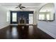 Cozy living room with stone fireplace, dark hardwood floors, and archway to the kitchen at 3228 Trinity Mill Cir, Dacula, GA 30019