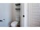 Powder room with a toilet and dark floating shelves at 3228 Trinity Mill Cir, Dacula, GA 30019