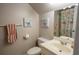 Bathroom with a white vanity, toilet, decorative paintings, and a patterned shower curtain at 5713 Brynwood Nw Cir, Acworth, GA 30101