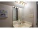 Bathroom vanity featuring a painting, modern faucet, and mirrored backsplash under bright lighting at 5713 Brynwood Nw Cir, Acworth, GA 30101