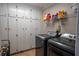 Laundry room with washer, dryer, and ample storage with white cabinets and gold hardware at 5713 Brynwood Nw Cir, Acworth, GA 30101