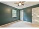 Bedroom with green accent wall, carpet, ceiling fan, and a white door at 622 Jockey Ln, Auburn, GA 30011