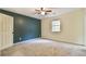 Large bedroom with green accent wall and neutral walls with a fan at 622 Jockey Ln, Auburn, GA 30011