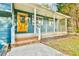 Cozy front porch with white railings and a bright yellow front door, inviting and charming at 622 Jockey Ln, Auburn, GA 30011