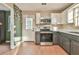 Modern kitchen with stainless steel appliances, white cabinets, and hardwood floors with a door to the backyard at 622 Jockey Ln, Auburn, GA 30011