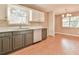 Kitchen area with stainless steel dishwasher and gray cabinets next to dining area at 622 Jockey Ln, Auburn, GA 30011
