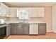 Well-lit kitchen featuring white cabinets, stainless steel appliances, and gray lower cabinets at 622 Jockey Ln, Auburn, GA 30011