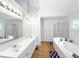Bright bathroom with dual vanity, large mirror, soaking tub, and glass enclosed shower at 3875 Ivy Run Cir, Duluth, GA 30096