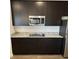 Kitchen with dark cabinetry, stainless appliances, granite countertops, and an island cooktop at 390 River Walk Farm Parkway Lot 47, Covington, GA 30014