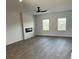 Open living room with sleek ceiling fan, fireplace, and luxury vinyl flooring at 390 River Walk Farm Parkway Lot 47, Covington, GA 30014
