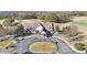 Aerial view of a well-maintained clubhouse surrounded by lush trees, featuring a circular driveway at 6048 Golf View Xing, Locust Grove, GA 30248