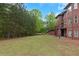 Spacious backyard with a well-maintained lawn and brick home in the background at 6048 Golf View Xing, Locust Grove, GA 30248