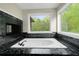 Relaxing bathtub features marble accents, and natural light from surrounding windows at 6048 Golf View Xing, Locust Grove, GA 30248