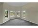 Bedroom featuring neutral walls, gray carpet and plenty of windows with views of the front yard at 6048 Golf View Xing, Locust Grove, GA 30248