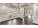 Formal dining room with coffered ceilings, wainscoting, and french doors leading to the front porch at 6048 Golf View Xing, Locust Grove, GA 30248