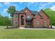 Stately brick home with manicured lawn and mature trees offering classic curb appeal at 6048 Golf View Xing, Locust Grove, GA 30248