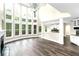 Bright living room featuring hardwood floors, fireplace, and two-story wall of windows at 6048 Golf View Xing, Locust Grove, GA 30248