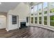 Bright living room featuring hardwood floors, fireplace, and two-story wall of windows at 6048 Golf View Xing, Locust Grove, GA 30248