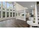 Spacious living room with hardwood floors, large windows, and elegant chandelier adjacent to the open concept kitchen at 6048 Golf View Xing, Locust Grove, GA 30248