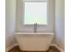 Elegant soaking tub under a bright window, complementing the modern bathroom design at 663 Egrets Landing Lot #55, Covington, GA 30014