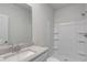 Bright bathroom boasts a granite countertop, white cabinets, and shower-tub combination at 663 Egrets Landing Lot #55, Covington, GA 30014