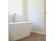 Bright white soaking tub in a bathroom with tile flooring and neutral colored walls at 663 Egrets Landing Lot #55, Covington, GA 30014