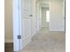 Light-filled bedroom featuring neutral carpet and multiple doorways at 663 Egrets Landing Lot #55, Covington, GA 30014