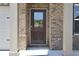 Close-up of the front door with glass insert, brick surround, and modern hardware, adding curb appeal at 663 Egrets Landing Lot #55, Covington, GA 30014