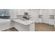 Bright kitchen features white cabinets, stone countertops, stainless steel appliances, and breakfast bar at 663 Egrets Landing Lot #55, Covington, GA 30014