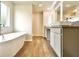 Bright bathroom features a standalone tub, double sink vanity, and wood-look tile flooring at 669 Egrets Lot 56 Lndg, Covington, GA 30014