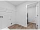 Functional laundry room with wood-look flooring and storage shelving at 669 Egrets Lot 56 Lndg, Covington, GA 30014
