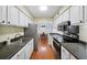 Galley kitchen with white cabinets, modern appliances and eat-in dining area at 5141 Roswell Rd # 7, Atlanta, GA 30342