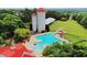 Expansive aerial shot of the outdoor pool with water slide, umbrellas, silo, lounge chairs, and trees at 679 Egrets Landing Lot 57, Covington, GA 30014